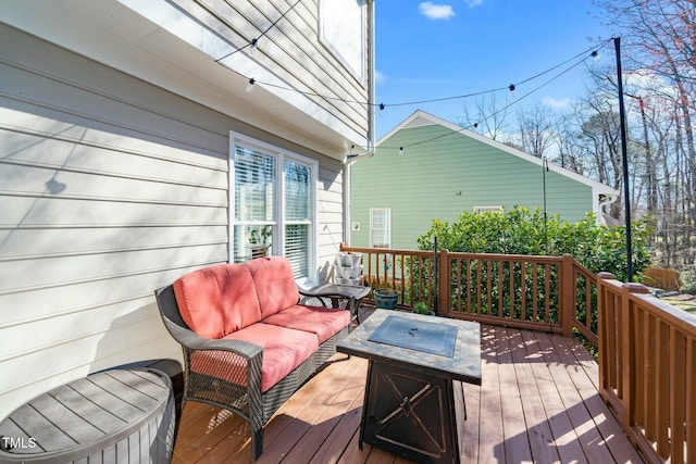 deck featuring an outdoor living space with a fire pit