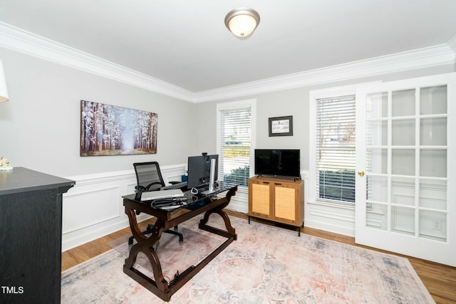 office space featuring wainscoting, light wood-type flooring, and ornamental molding