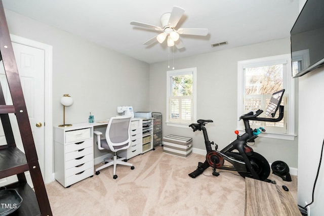 office space featuring visible vents, light colored carpet, baseboards, and ceiling fan