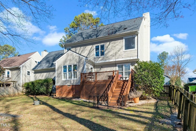 rear view of house with a wooden deck, stairs, a chimney, a fenced backyard, and a yard