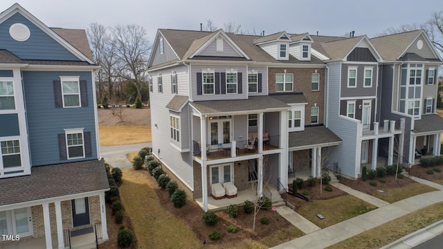 view of property with a residential view, a shingled roof, and a balcony