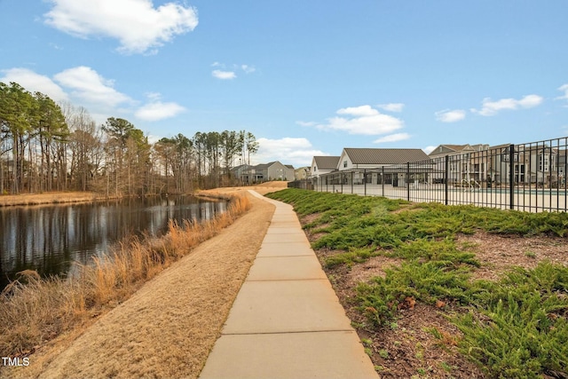 view of community with fence and a water view