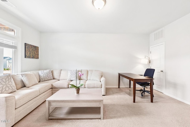 carpeted living room featuring a wealth of natural light, visible vents, and baseboards