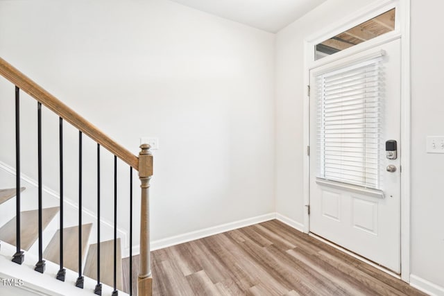 entryway featuring stairway, baseboards, and wood finished floors