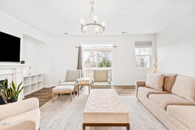 living room with wood finished floors, visible vents, and baseboards