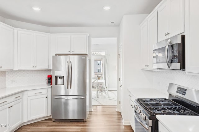 kitchen featuring light wood-type flooring, stainless steel appliances, and white cabinets