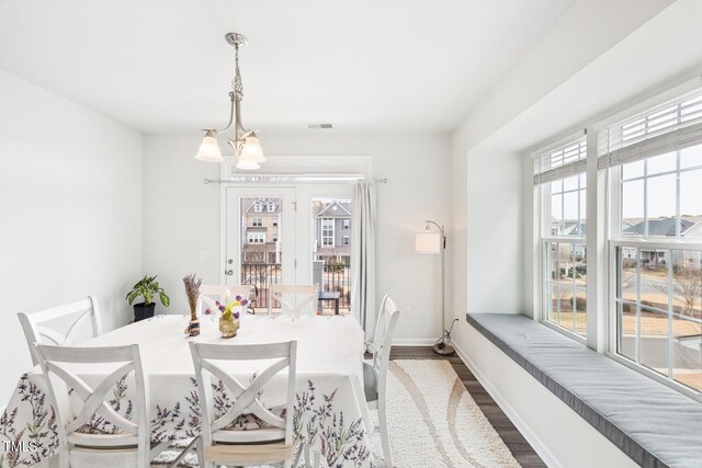 dining room featuring visible vents, baseboards, a notable chandelier, and dark wood-style flooring