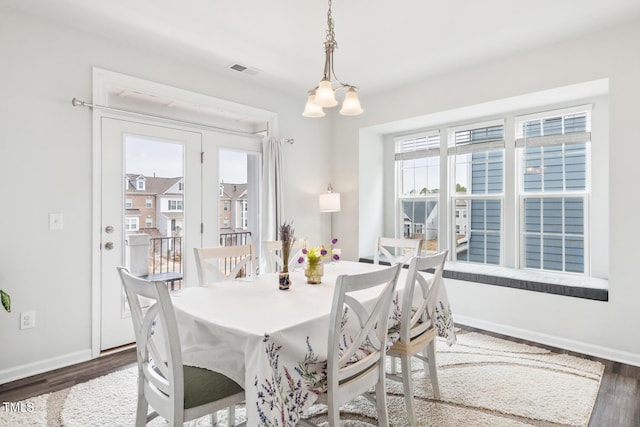 dining room featuring wood finished floors, visible vents, and baseboards