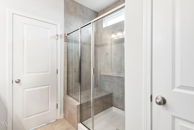 full bathroom featuring a stall shower and tile patterned flooring