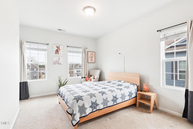 carpeted bedroom featuring visible vents and baseboards