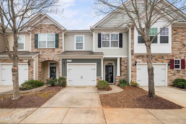 multi unit property featuring concrete driveway, a garage, and stone siding