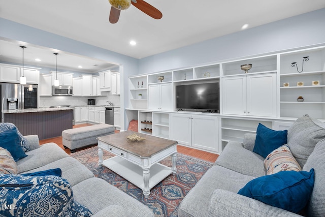 living room with recessed lighting, light wood-type flooring, and ceiling fan