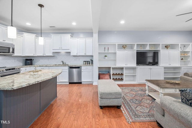 kitchen featuring white cabinetry, light stone countertops, light wood-style floors, and appliances with stainless steel finishes