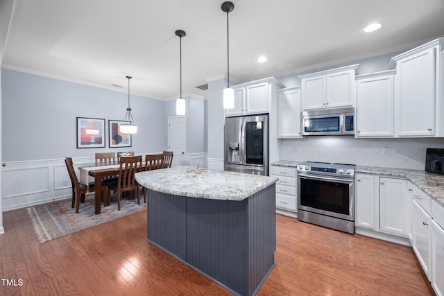 kitchen with white cabinets, stainless steel appliances, and light wood-type flooring