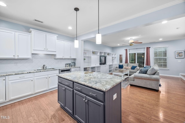 kitchen with a sink, crown molding, white cabinets, and gray cabinetry