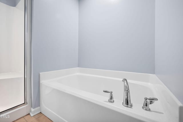 bathroom featuring tile patterned floors, a garden tub, and a stall shower