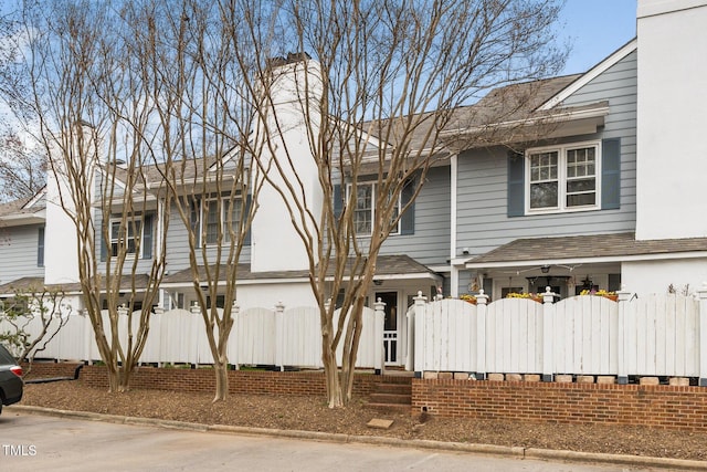 view of front of property with a gate, a fenced front yard, and a shingled roof