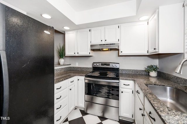 kitchen with under cabinet range hood, stainless steel range with electric cooktop, freestanding refrigerator, tile patterned floors, and a sink