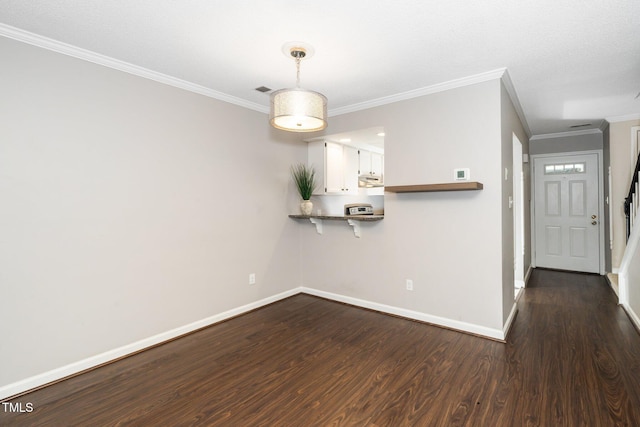 spare room featuring dark wood-type flooring, baseboards, and ornamental molding