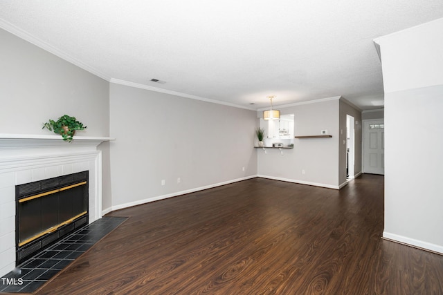 unfurnished living room featuring wood finished floors, baseboards, visible vents, ornamental molding, and a tile fireplace