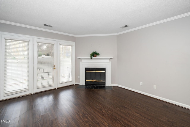 unfurnished living room with visible vents, wood finished floors, a tiled fireplace, and crown molding