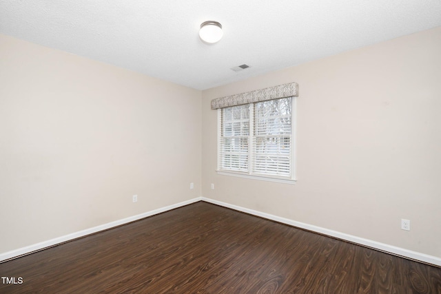 unfurnished room with visible vents, baseboards, and wood finished floors