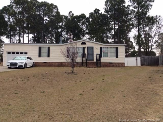 manufactured / mobile home with crawl space, an attached garage, and fence