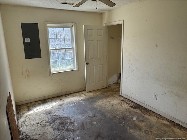 empty room with electric panel, visible vents, and a ceiling fan