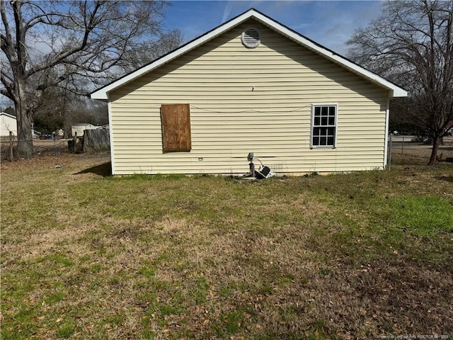 view of property exterior with a lawn and fence