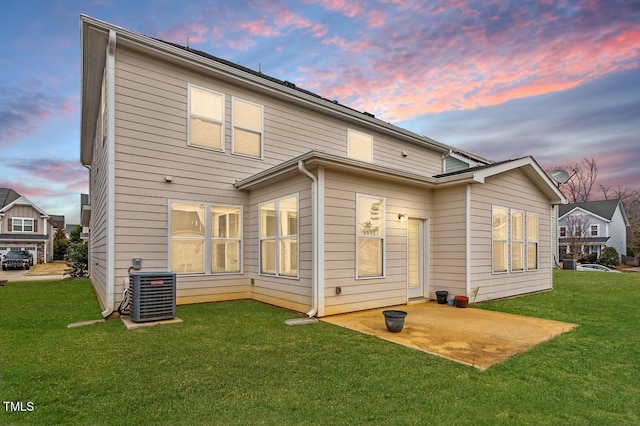 back of house featuring a yard and central AC