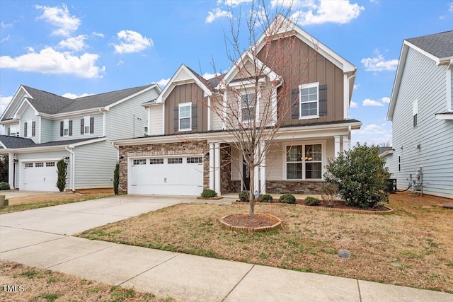 craftsman inspired home with a garage, stone siding, board and batten siding, and driveway