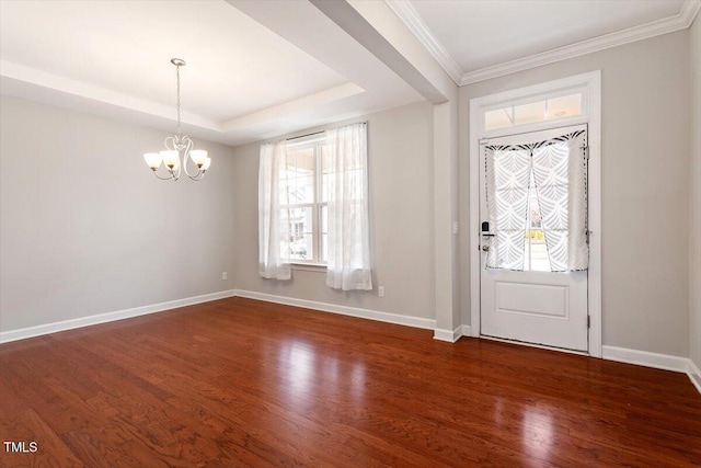 foyer entrance with a notable chandelier, baseboards, a raised ceiling, and dark wood-type flooring