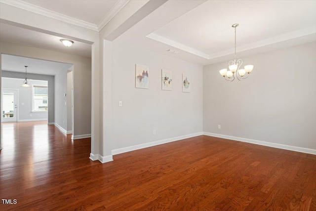 unfurnished room featuring dark wood-style floors, a chandelier, a tray ceiling, and baseboards