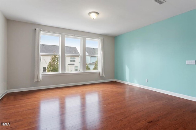 unfurnished room featuring baseboards and wood finished floors