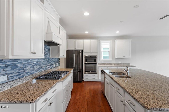 kitchen featuring visible vents, dark wood finished floors, a sink, stainless steel appliances, and white cabinets