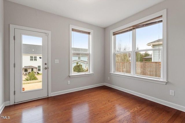 interior space featuring plenty of natural light, wood finished floors, and baseboards