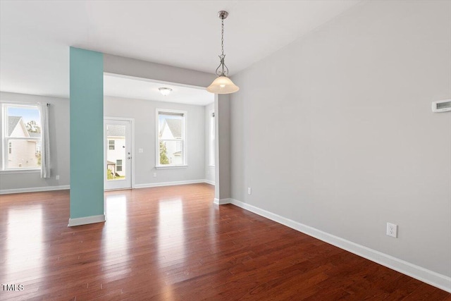 empty room with dark wood finished floors and baseboards