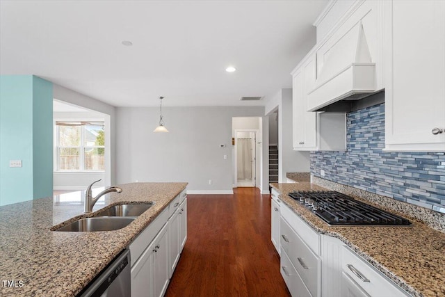 kitchen featuring premium range hood, visible vents, a sink, decorative backsplash, and appliances with stainless steel finishes