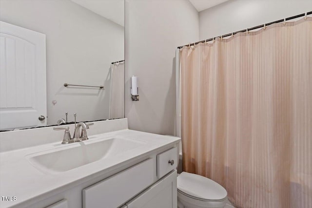 bathroom featuring curtained shower, toilet, and vanity