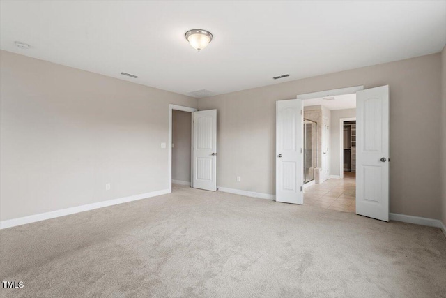 unfurnished bedroom with light carpet, visible vents, and baseboards