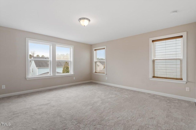 spare room with baseboards and carpet flooring