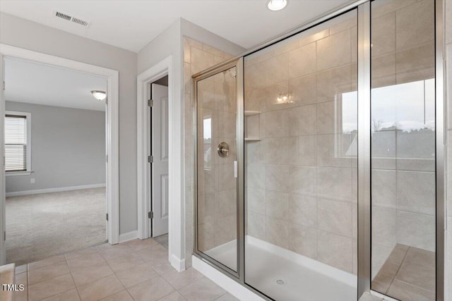 bathroom featuring tile patterned floors, visible vents, a shower stall, and baseboards