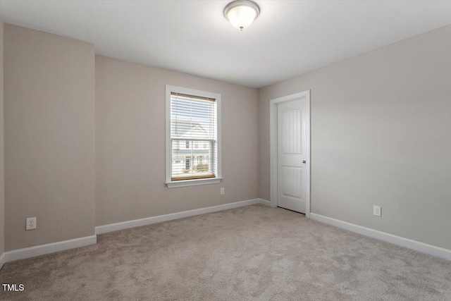 carpeted empty room featuring baseboards