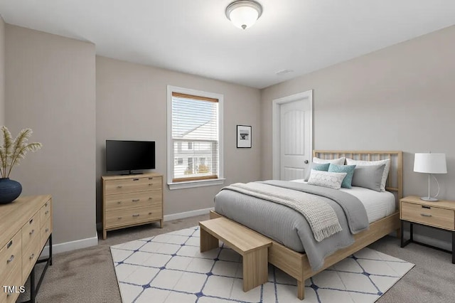 bedroom featuring light colored carpet and baseboards