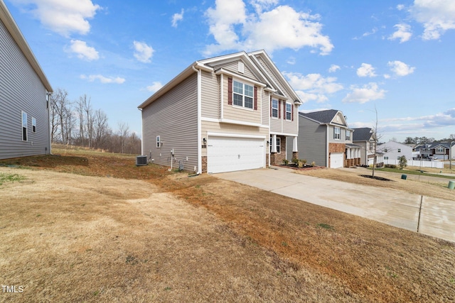 view of home's exterior with a residential view, an attached garage, concrete driveway, and central air condition unit