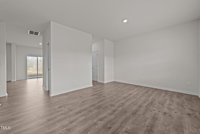 spare room featuring visible vents, baseboards, and wood finished floors