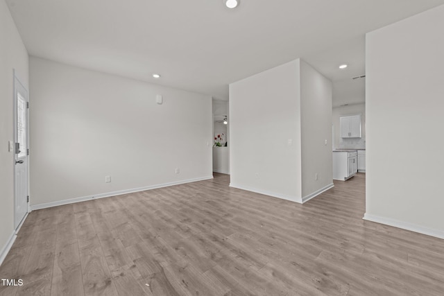 unfurnished living room featuring recessed lighting, baseboards, and light wood-style floors