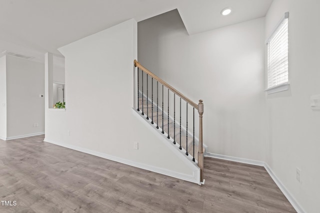 stairway with recessed lighting, wood finished floors, visible vents, and baseboards