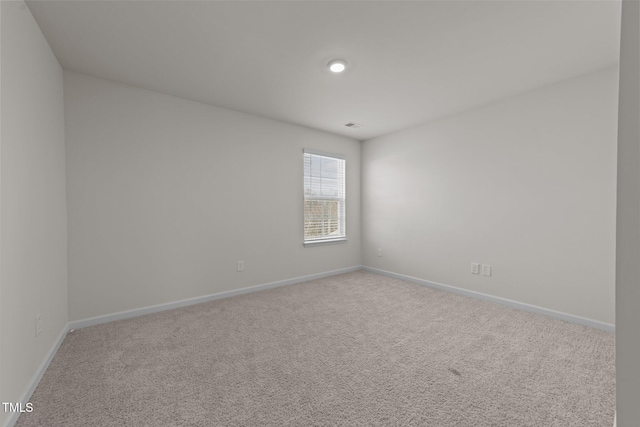 carpeted empty room featuring baseboards