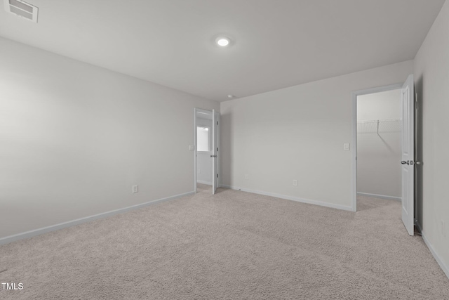 unfurnished room with light colored carpet, visible vents, and baseboards